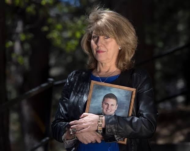 Wendy McEntyre holding a photograph in memory of her son Jarrod
