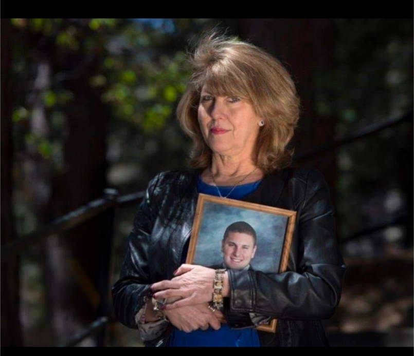 Wendy McEntyre holding a photograph in memory of her son